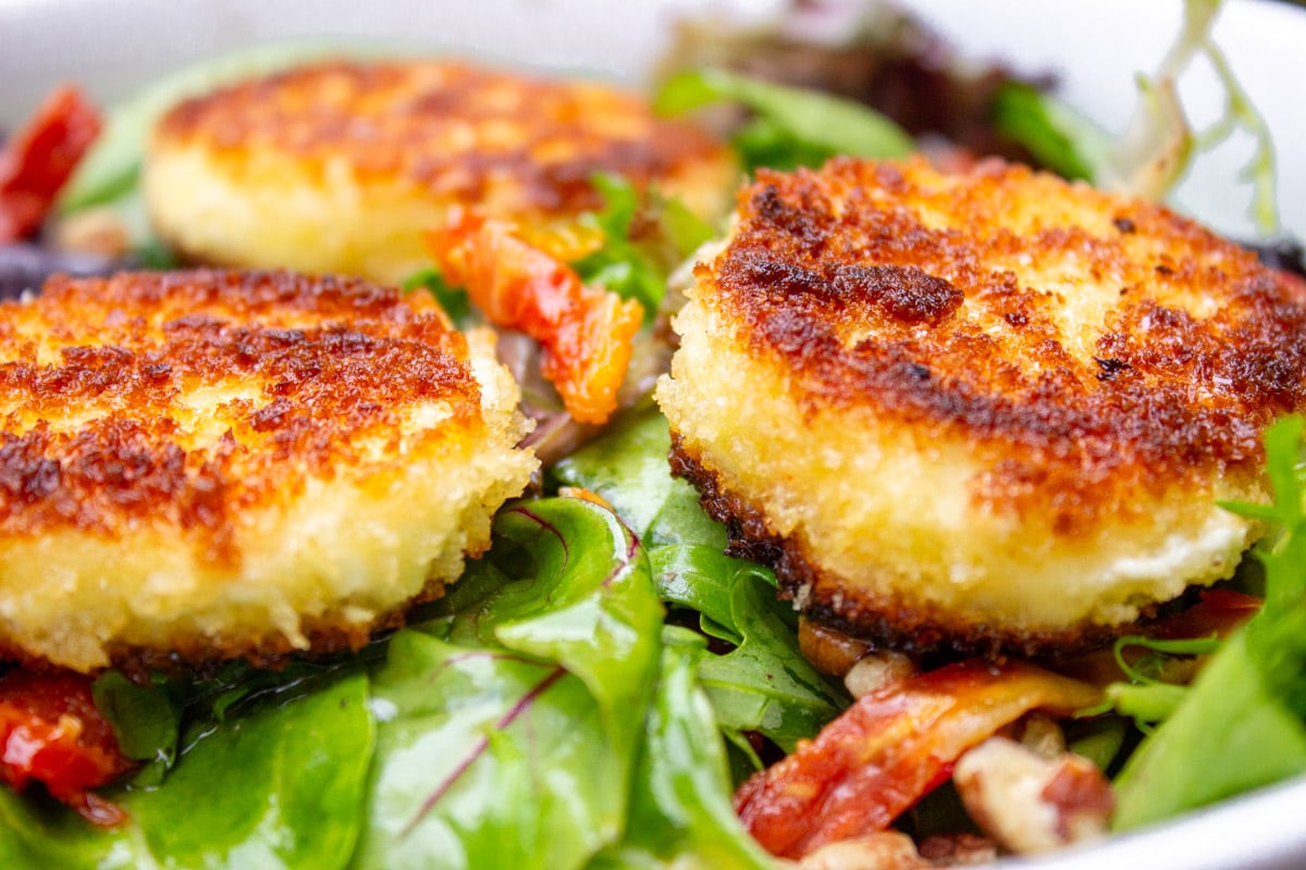 3 fried crusted goat cheese rounds on dressed.