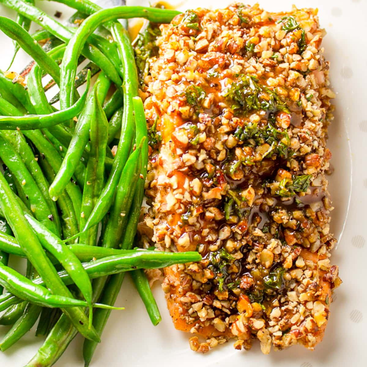 pecan crusted salmon with green beans on plate.