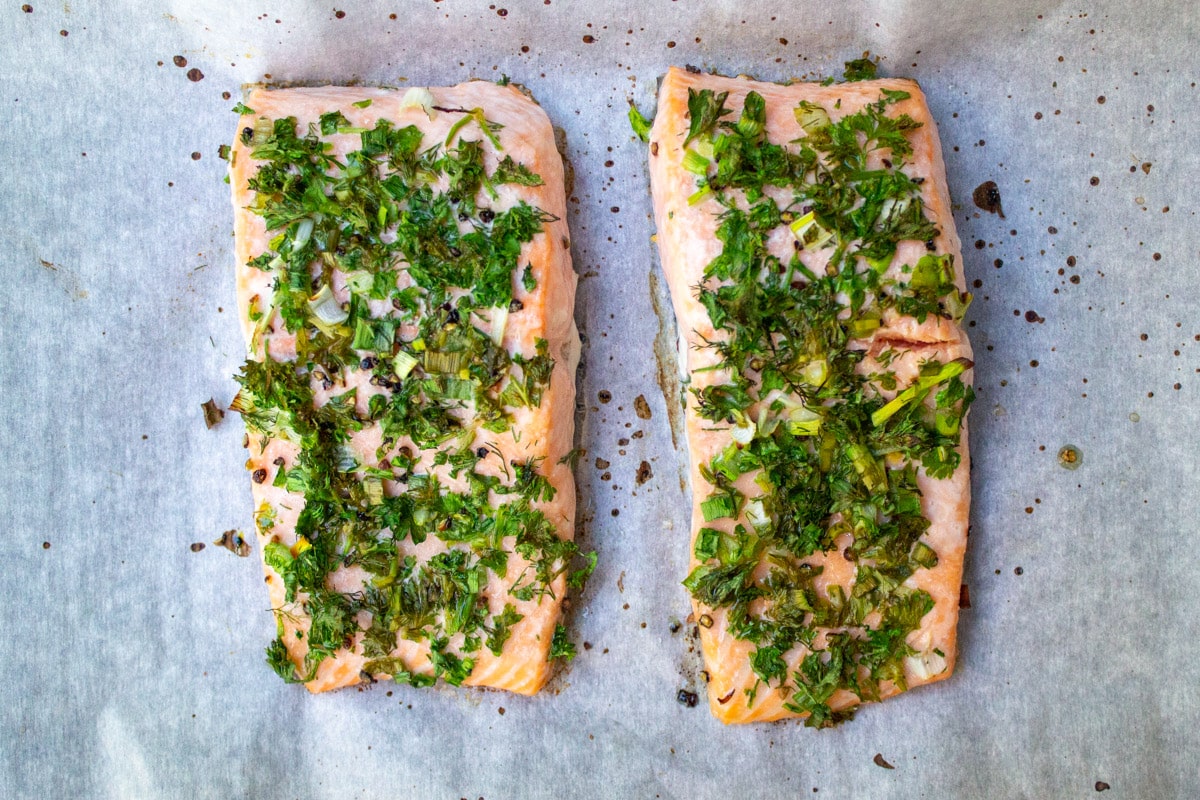 baked salmon fillets with herbs on top.