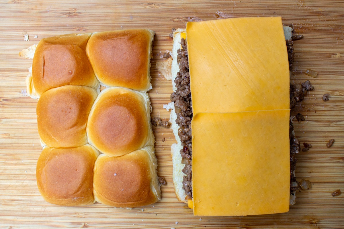 cheese laid on top of ground beef mixture on lower half of rolls.