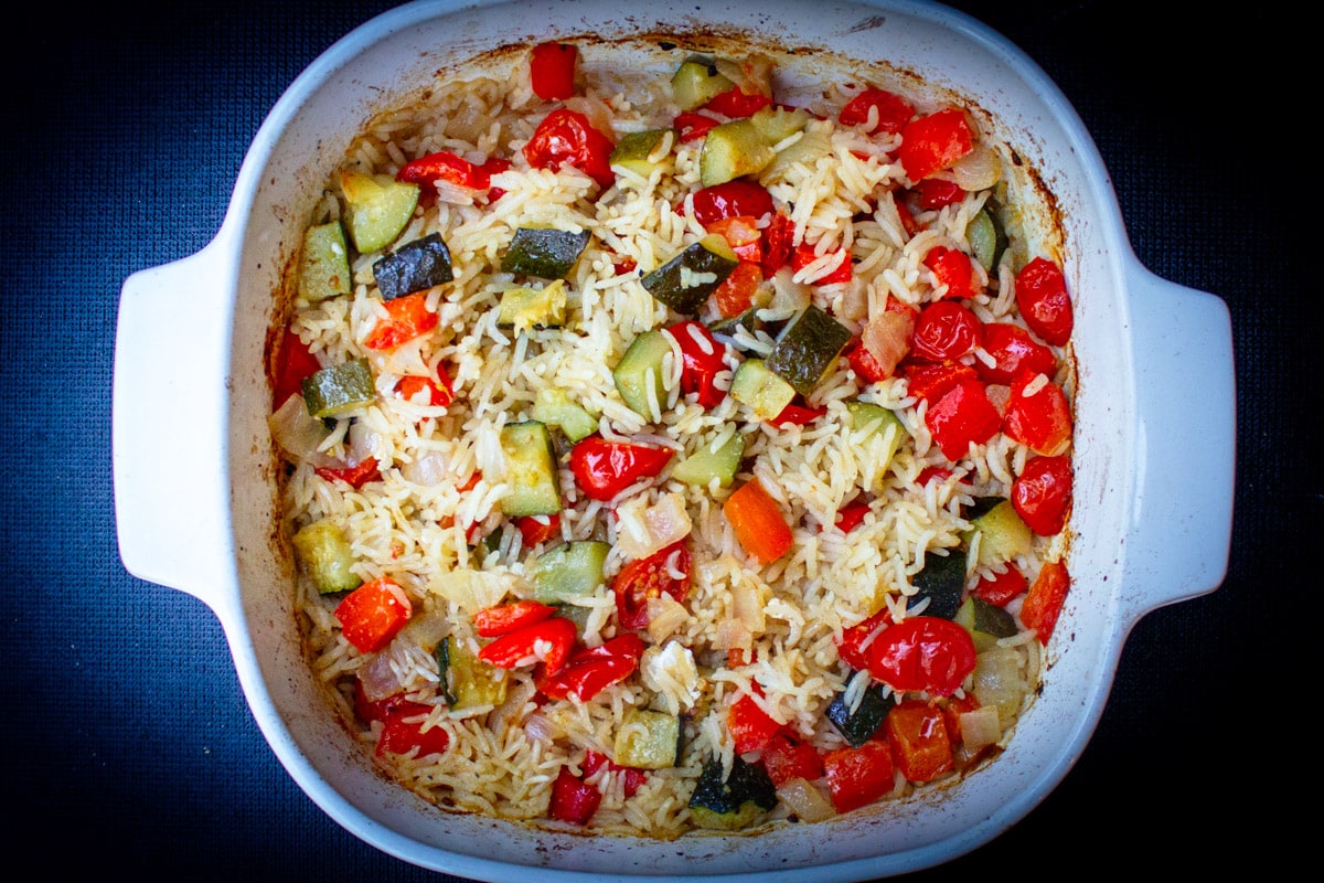 baked mediterranean rice with vegetables in casserole dish. 
