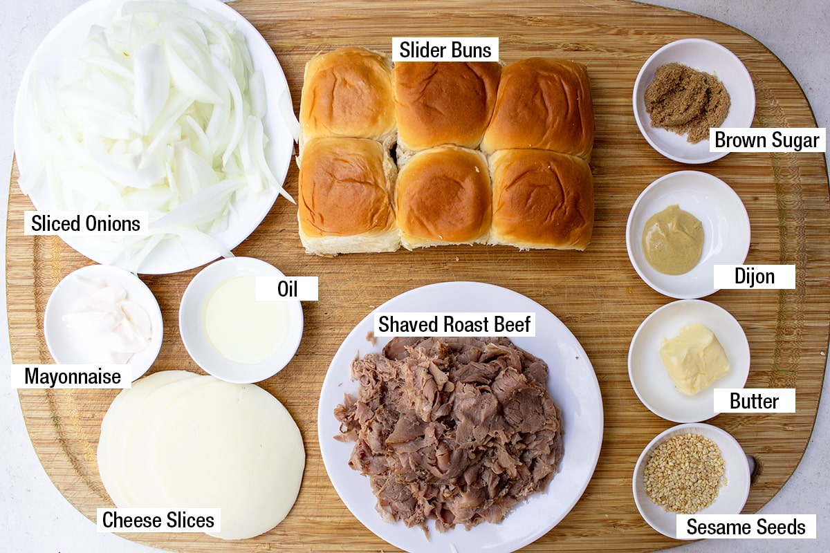 slider buns, shaved roast beef, sliced onions, cheese slices, mayonnaise, oil, brown sugar, butter, Dijon, sesame seeds.