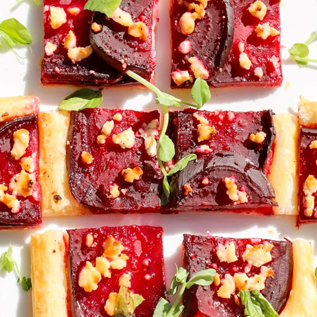 beet and goat cheese puff pastry tart appetizer cut into squares.