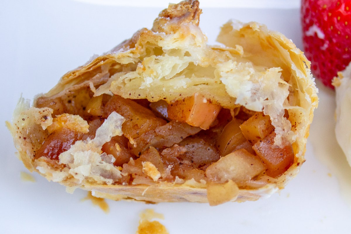 cut open mini apple pie on plate.