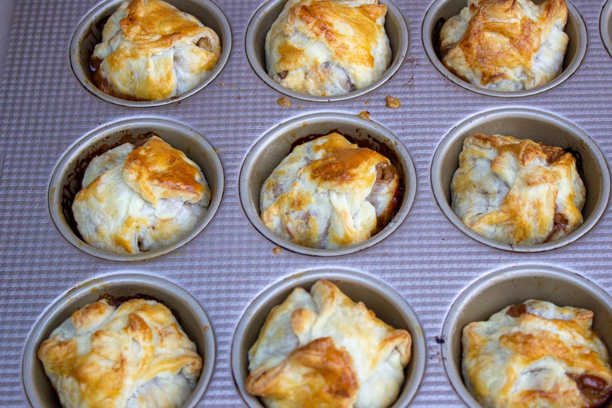 baked mini apple pies in muffin tin cups.