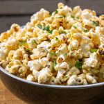 butter herb popcorn in a bowl on table.