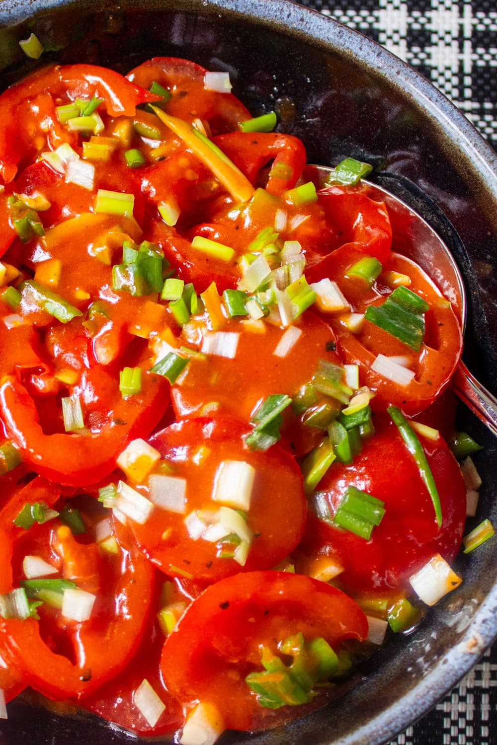 marinated tomato and green onion salad in bowl.