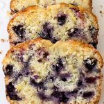 Sliced lemon blueberry loaf on white plate.
