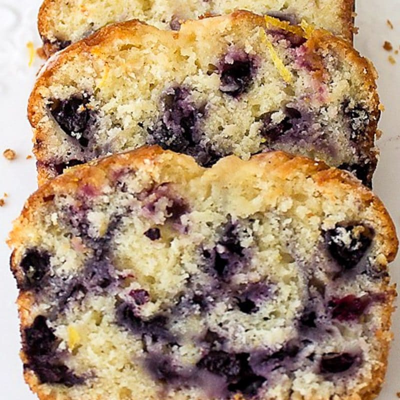 Sliced lemon blueberry loaf on white plate.