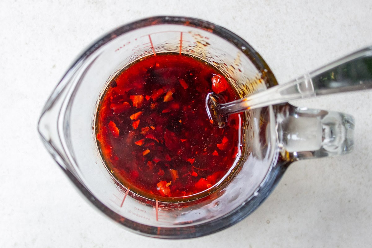 chili crisp sauce mixture in glass measuring cup.