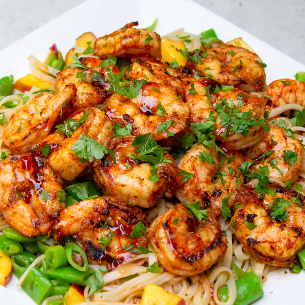 BBQ shrimp over noodles with snap peas and peaches.