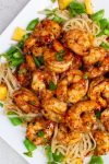 BBQ shrimp over noodles with snap peas and peaches.