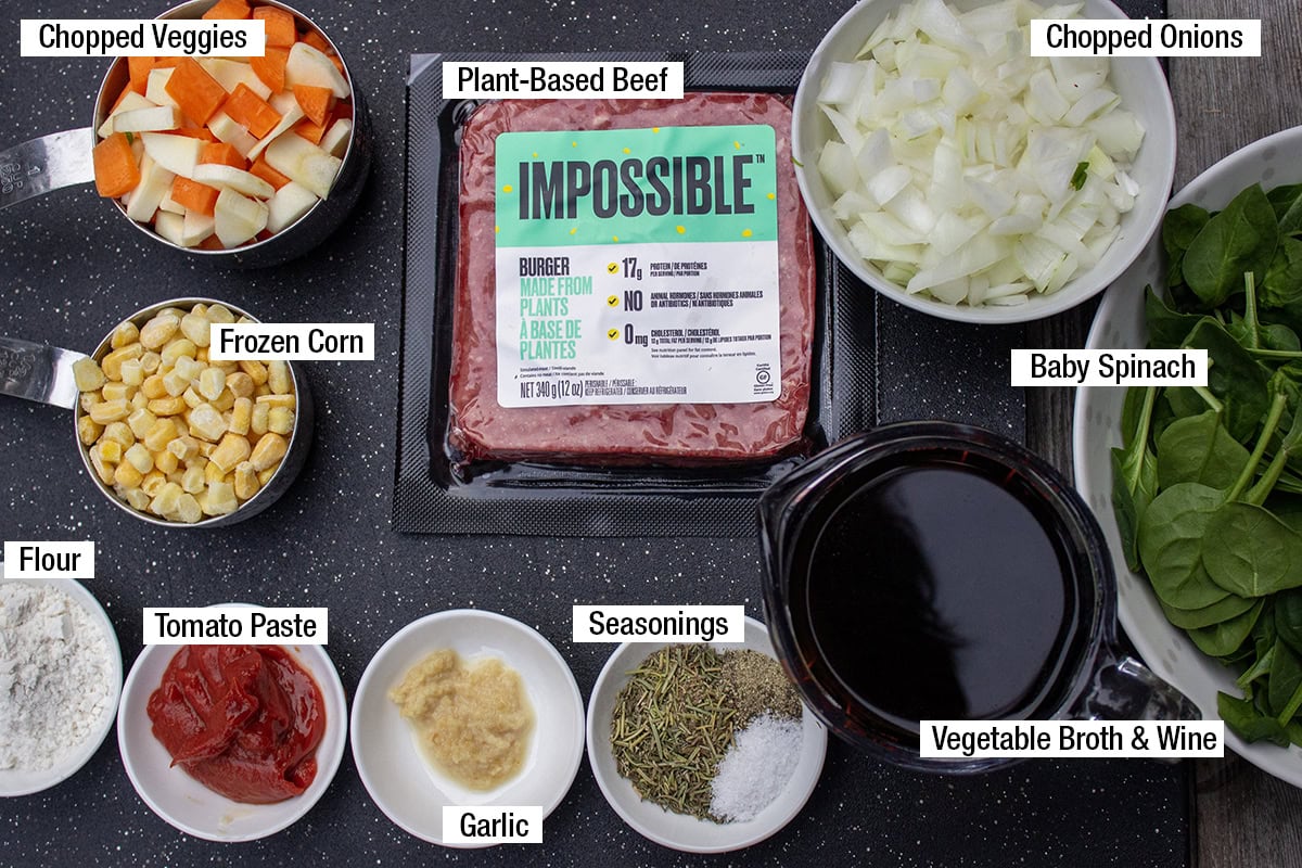 Plant-based beef, chopped onions, chopped veggies, frozen corn, baby spinach, seasonings, flour, garlic, tomato paste, vegetable broth & wine.