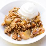 Serving of apple crisp with vanilla ice cream in a bowl.