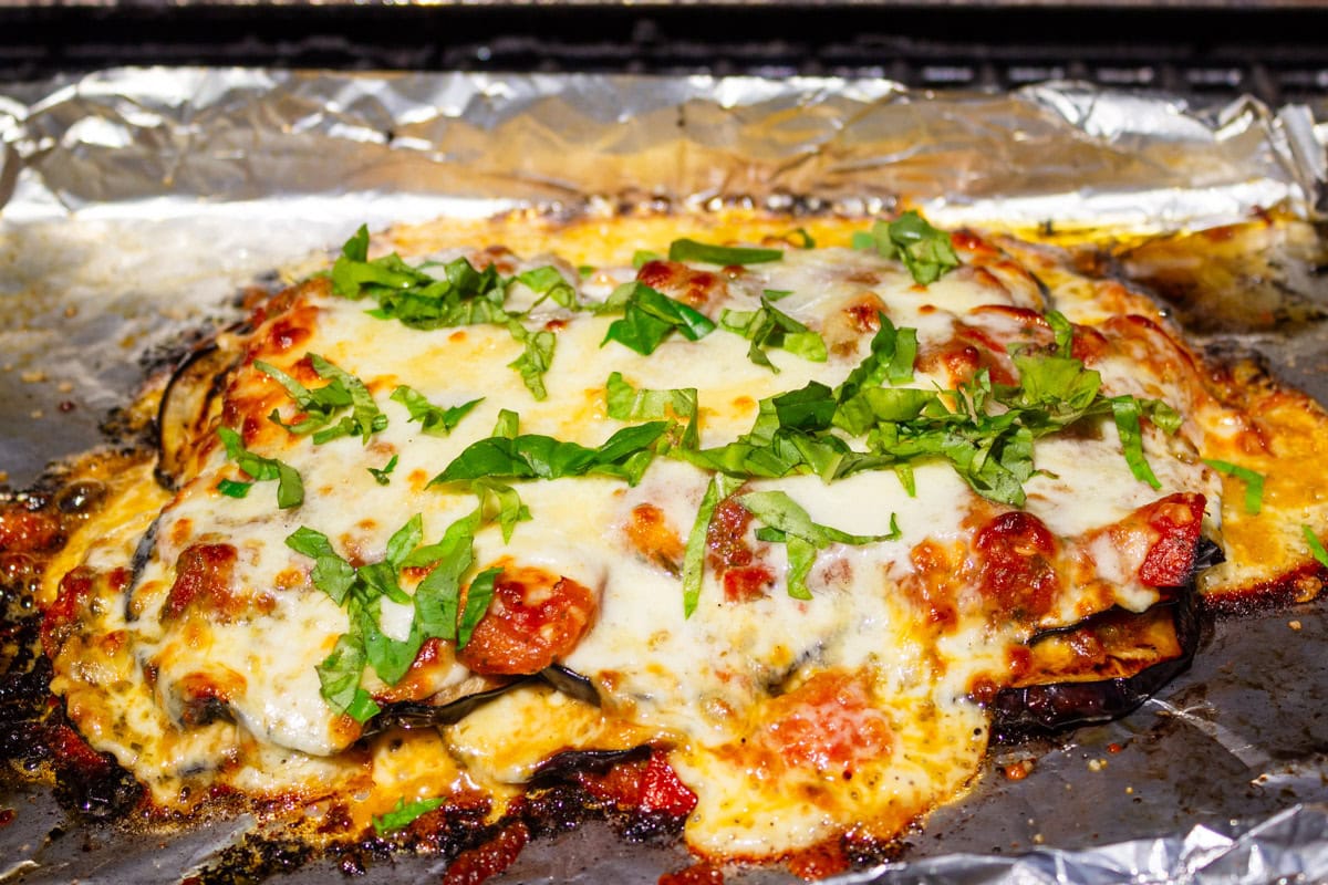 Eggplant parmesan baked on the grill in a pan.