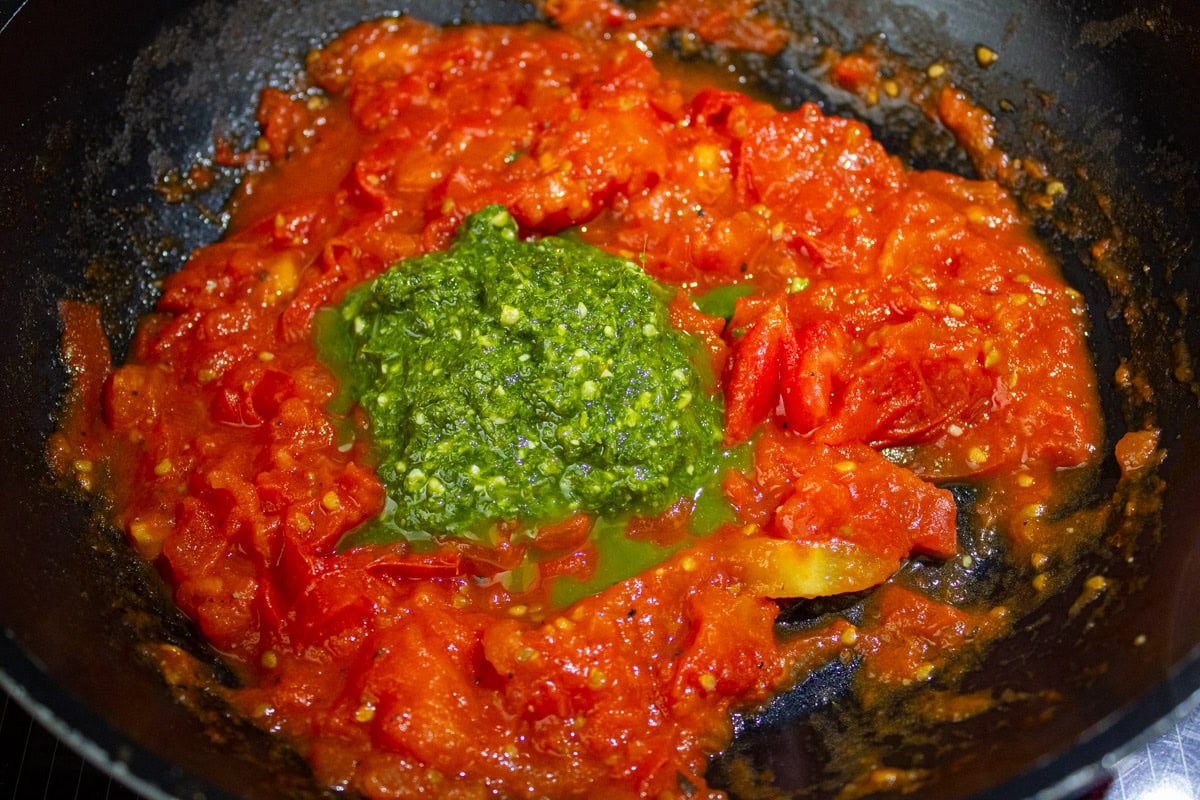 Basil added to tomato mixture in skillet.