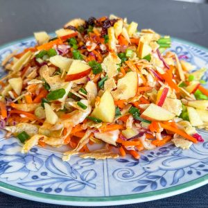 Asian style coleslaw on a plate with crunchy garnish.