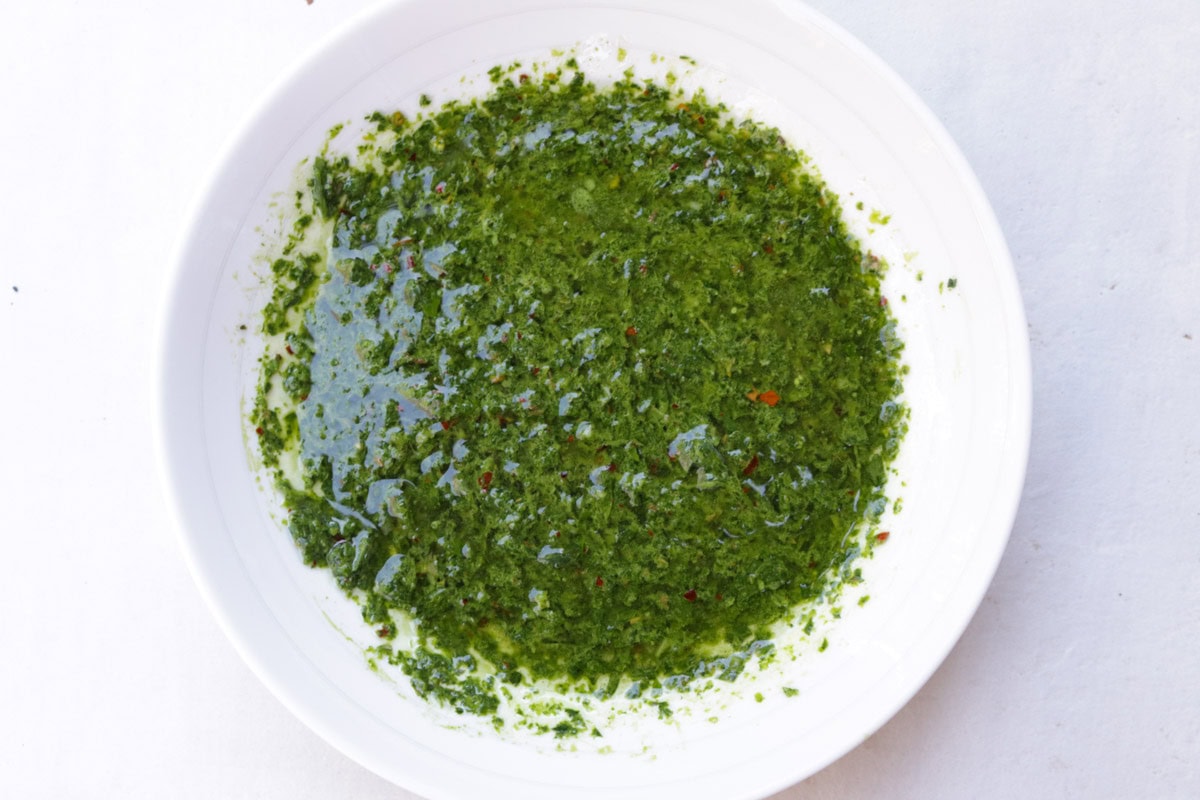 Chimichurri sauce in white bowl.