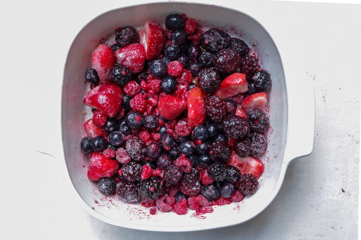 Berries and maple syrup in baking dish.