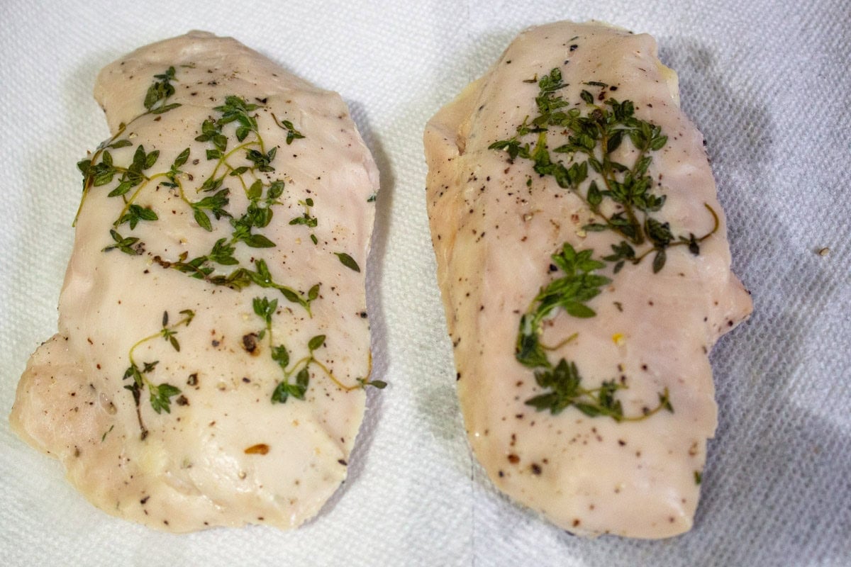 Two post sous vide chicken breasts on a paper towel.
