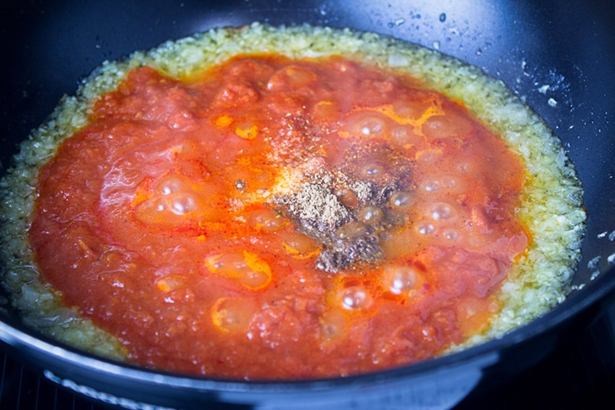 Minced onions, tomato sauce, and Indian seasonings in skillet.