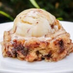 Single serve coffee cake on a plate with ice cream on top.