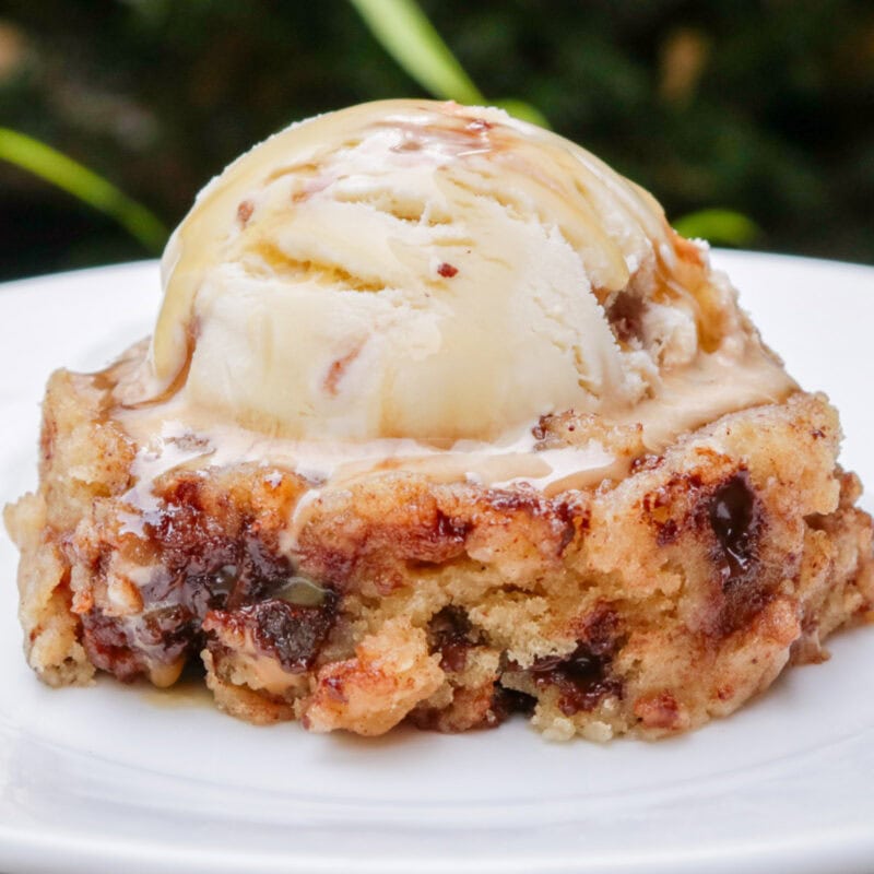 Single serve coffee cake on a plate with ice cream on top.