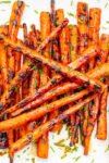 Glazed grilled balsamic carrots on plate garnished with fresh thyme.