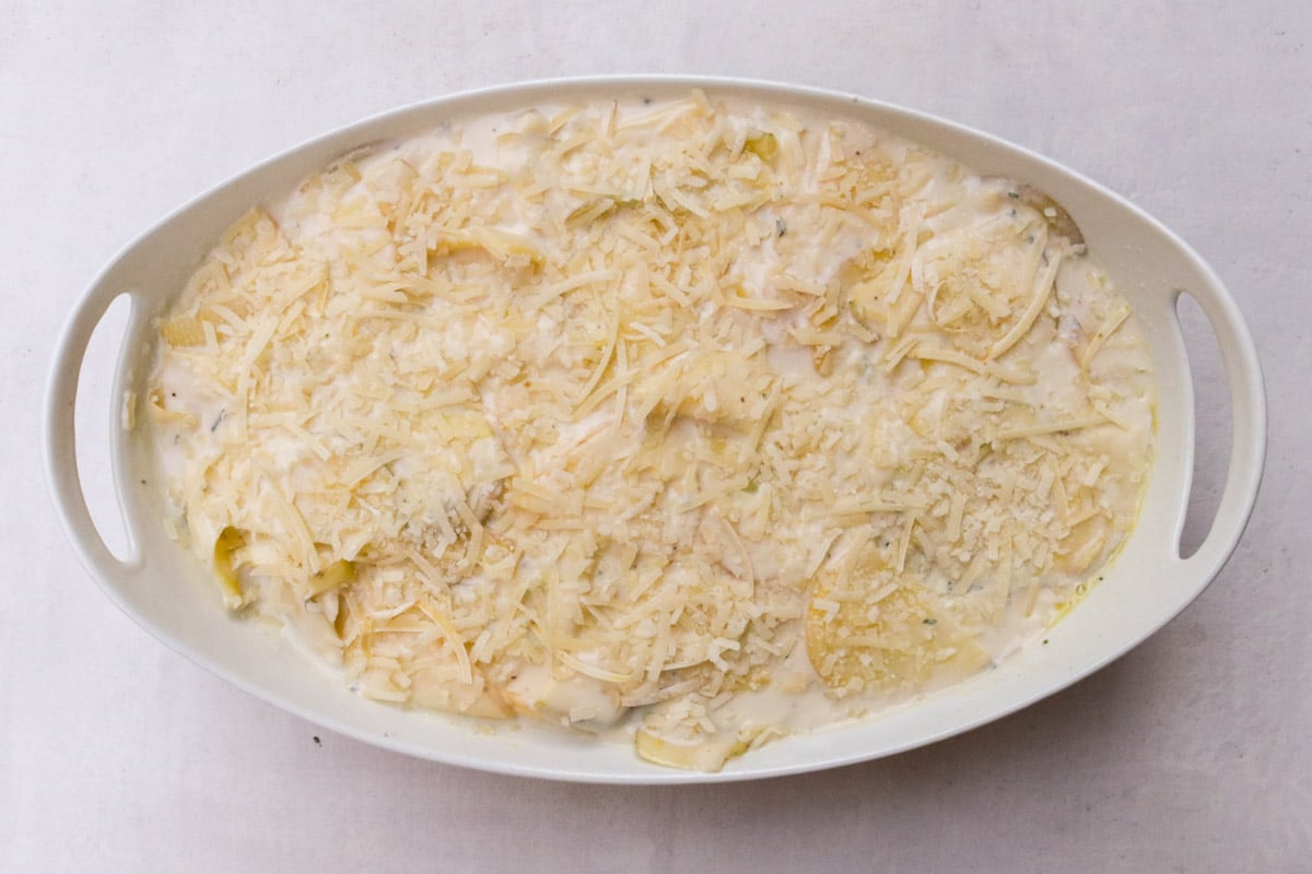 Potato mixture in casserole dish topped with Parmesan.