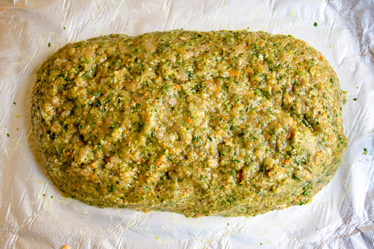 Raw chicken meatloaf unglazed on parchment lined pan. 