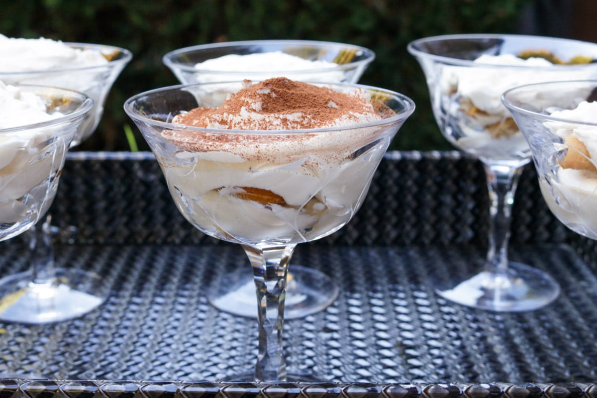 6 tiramisu cups on a woven tray. 