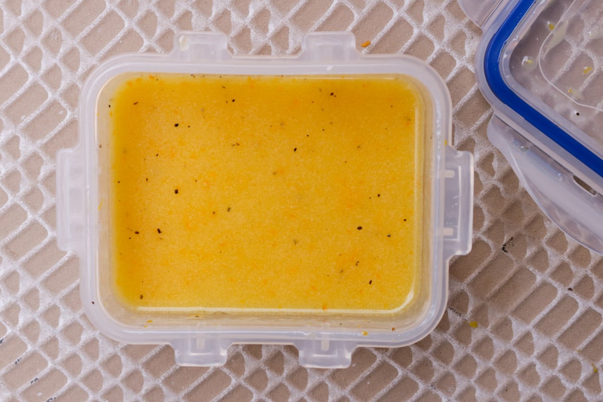 Mandarin orange vinaigrette in a small plastic container.
