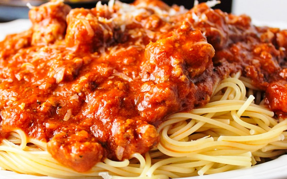 Meat sauce over spaghetti on a plate.