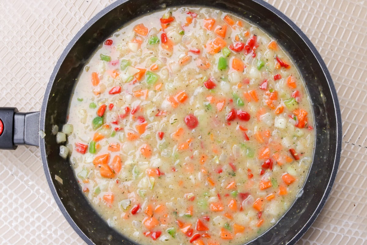 Frozen veggies in chicken sauce in a skillet.