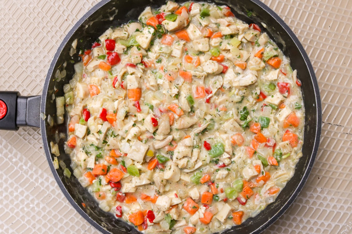 Chicken pot pie filling in a skillet.