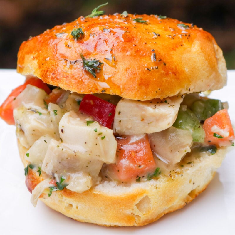 Slider biscuit filled with chicken pot pie filling on a plate.