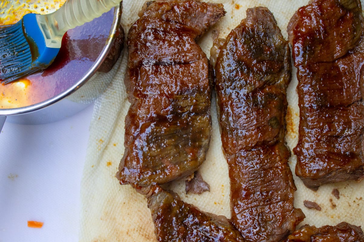 Beef short ribs glazed on cutting board.