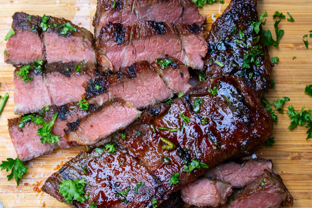 Grilled sous vide boneless beef short ribs sliced on cutting boaqrd.