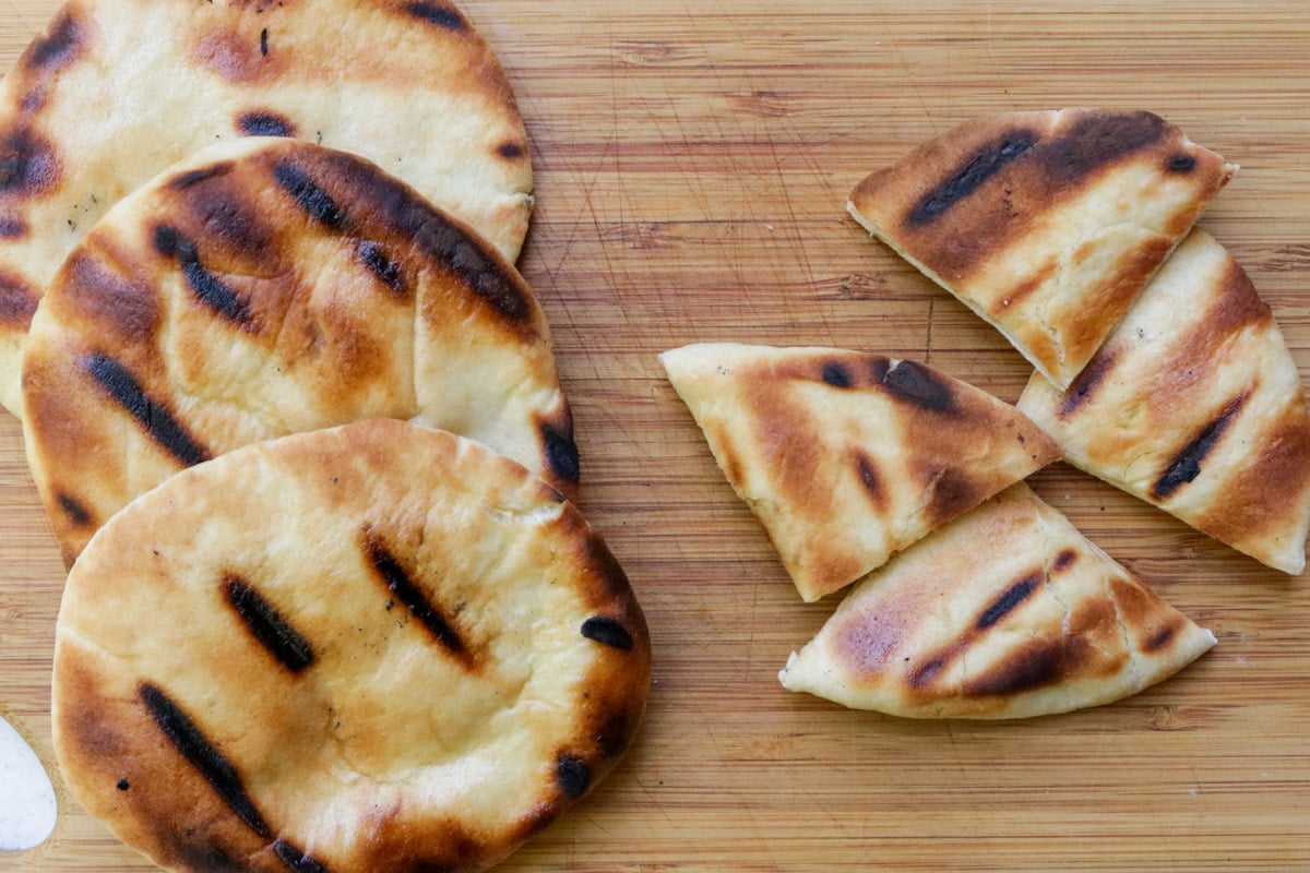 Grilled pita on cutting board.