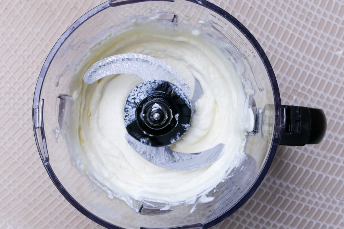 Whipped ricotta in a food processor bowl,