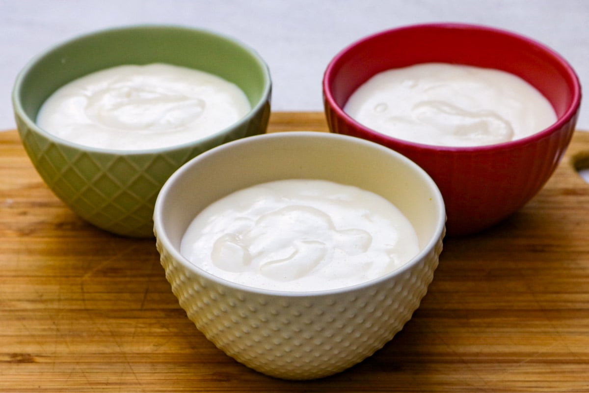 Plain vanilla pudding in 3 colored bowls.