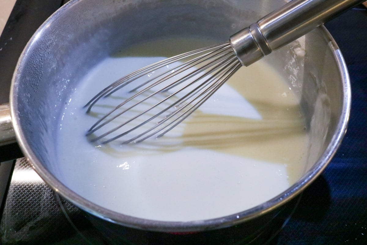 Pudding mixture thickened in pot with whisk.