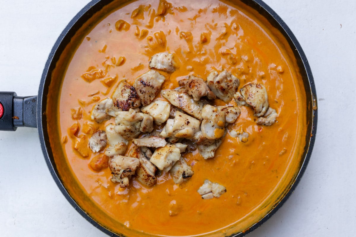 Chicken added to coconut curry sauce.