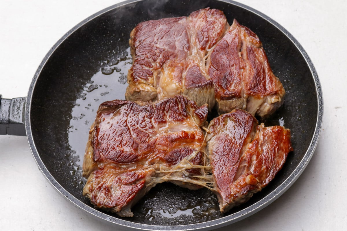Seared beef chuck in a skillet.