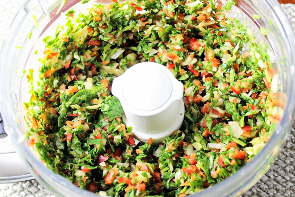 Finely chopped vegetables in food processor bowl.,