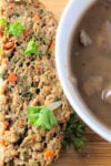 Slice of meatloaf beside small bowl of mushroom gravy.