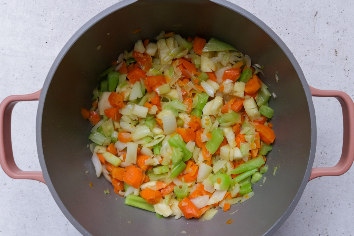 Sauteed vegetables mixed with flour in a pot.