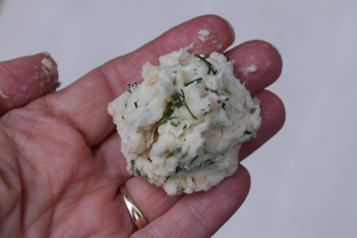 Small lump of dumpling dough in a hand.